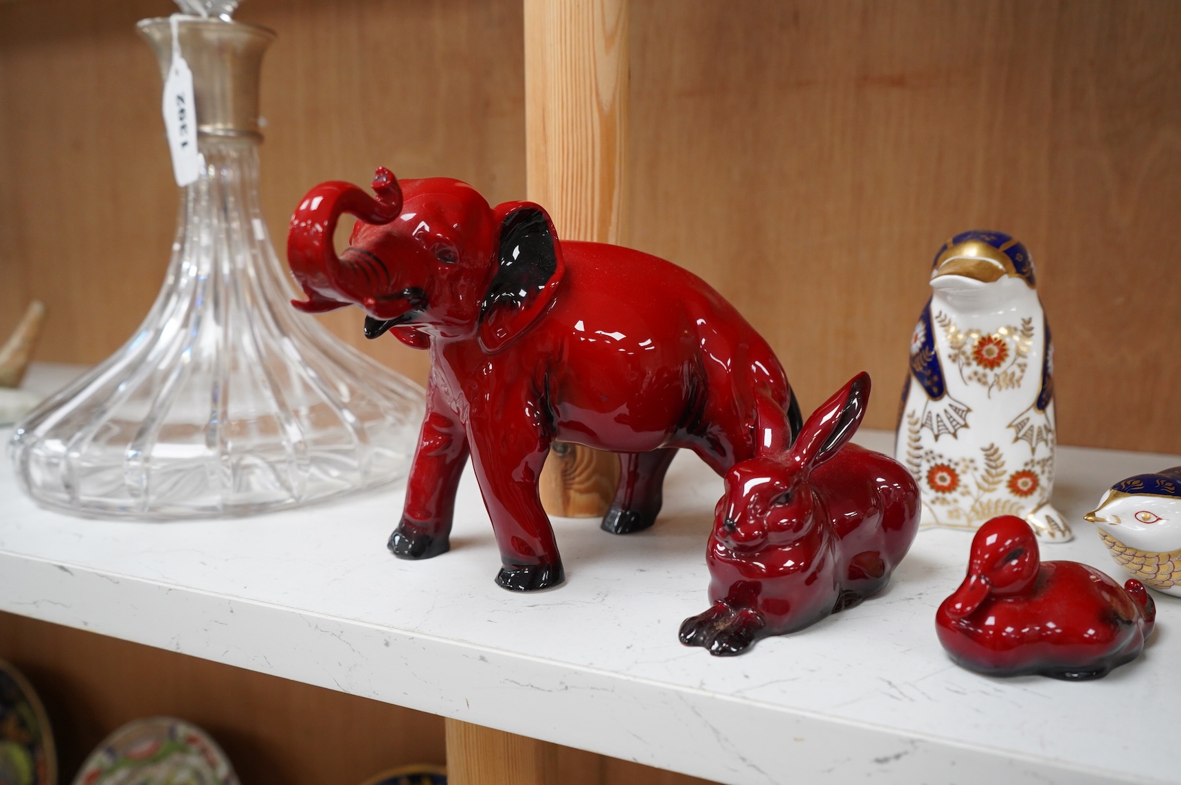 A collection of Royal Crown Derby Imari pattern paperweights, to include penguin and badger, together with three Doulton flambé animals, largest 19cm wide